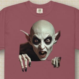 Product Image of the Lady Vamp T-Shirt, which shows a bald, female vampire breaking though the fabric of the shirt